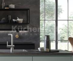 Cuisine ouverte chic avec îlot central au façades mates de couleur vert eucalyptus et un coin repas - 2
